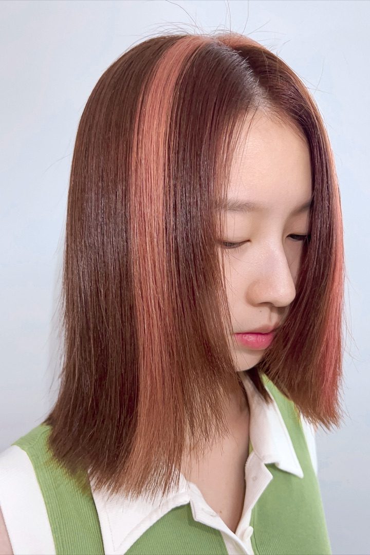 约一年后的设计：粉色带从内层走向表层，深色头发仍被保留